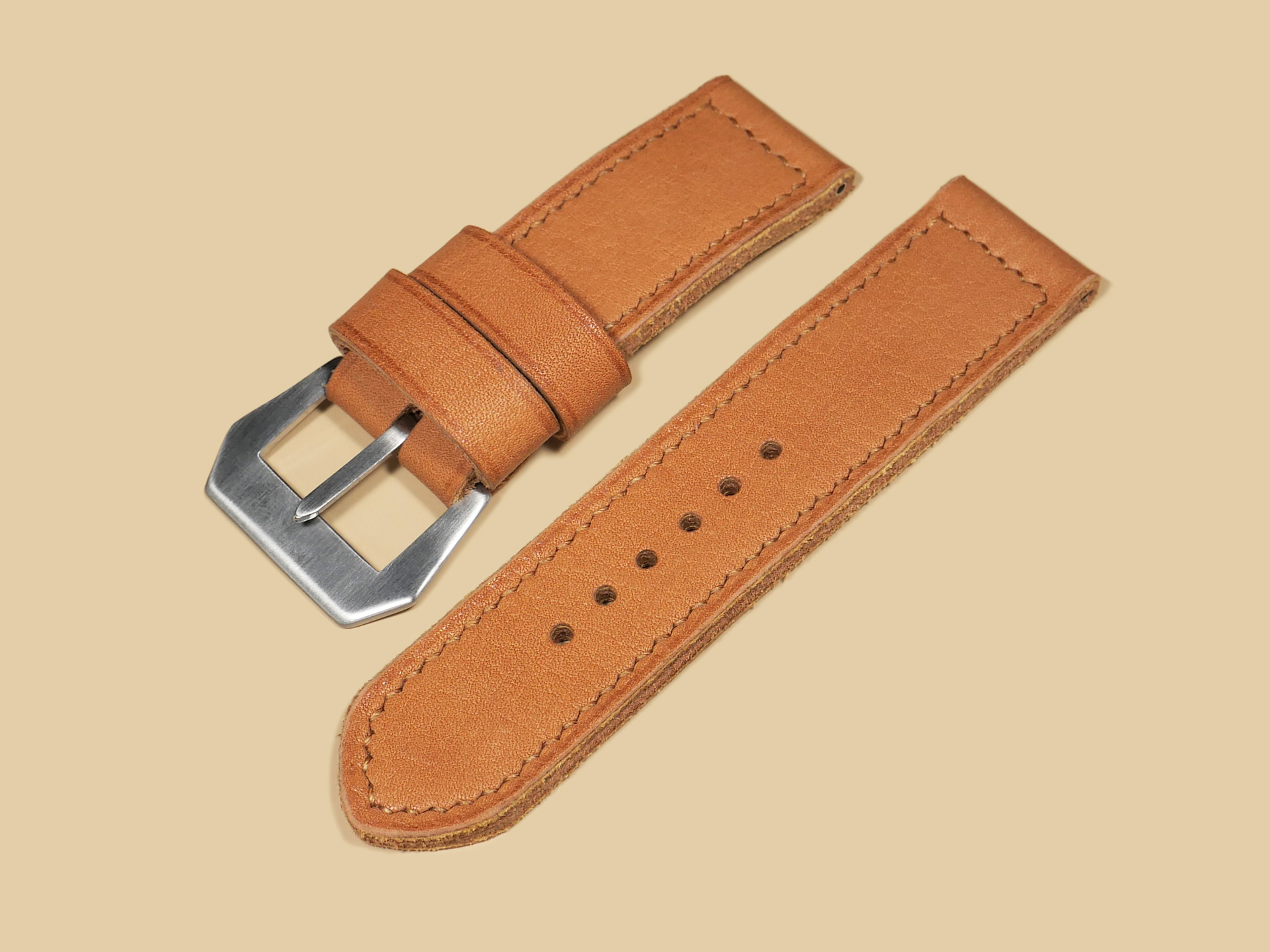 Thick Orange Panerai strap for 47mm Panerai watches displayed on a leather surface