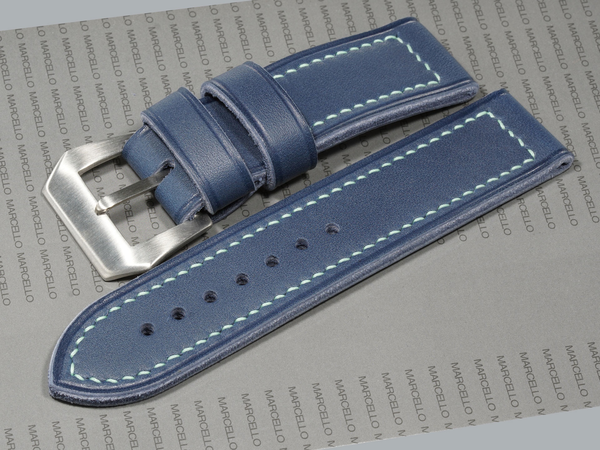 Side profile of blue Panerai strap showing curved sewn-in buckle