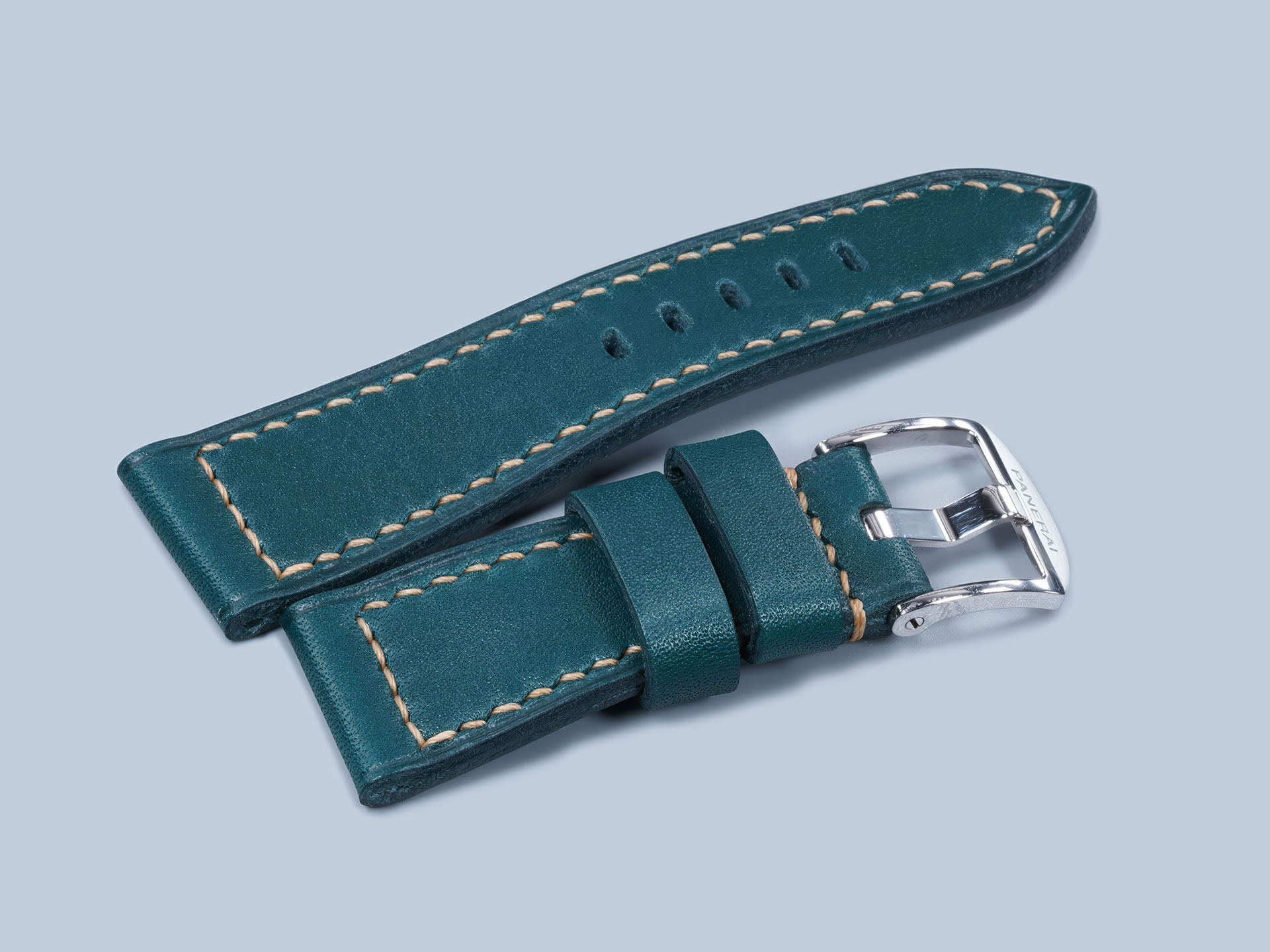 Hand-burnished edges on a dark teal handmade strap for Panerai Due.