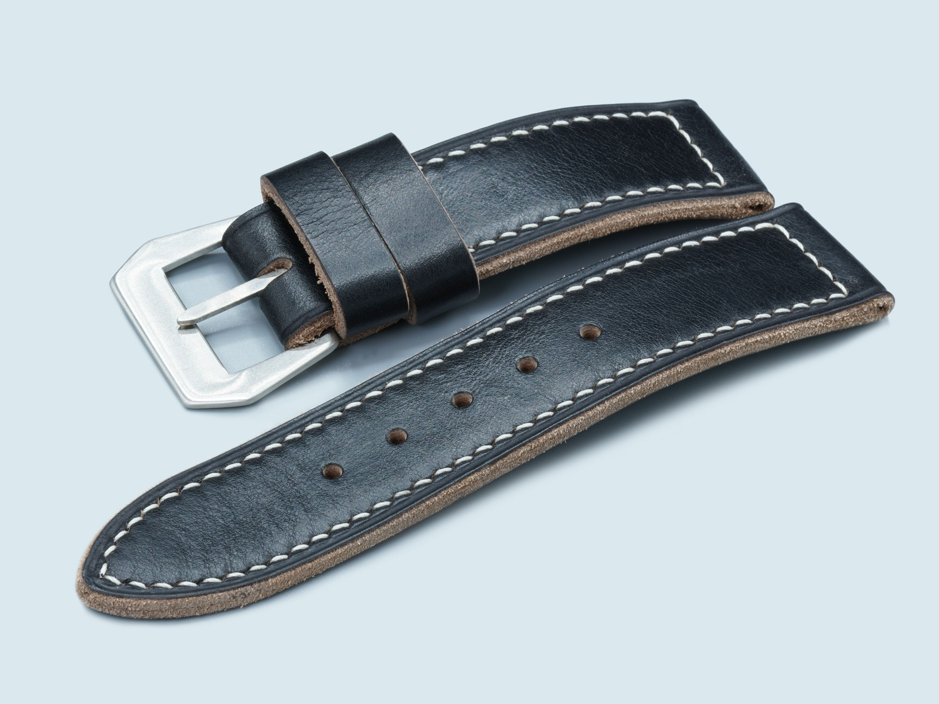 26mm lug width black strap tapering to a vintage-finish buckle.