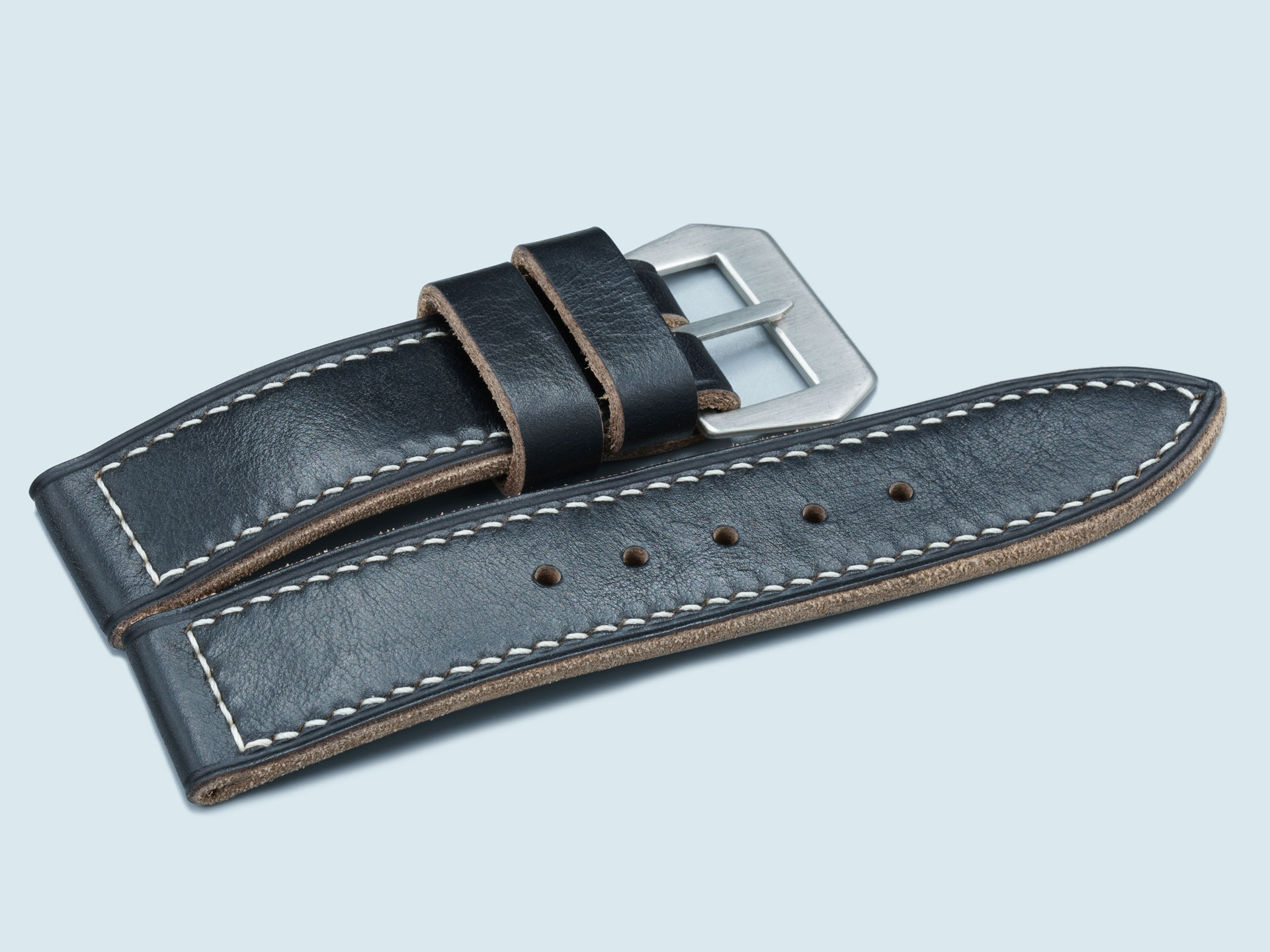 High-contrast macro shot of black pebble-grain leather for Panerai.