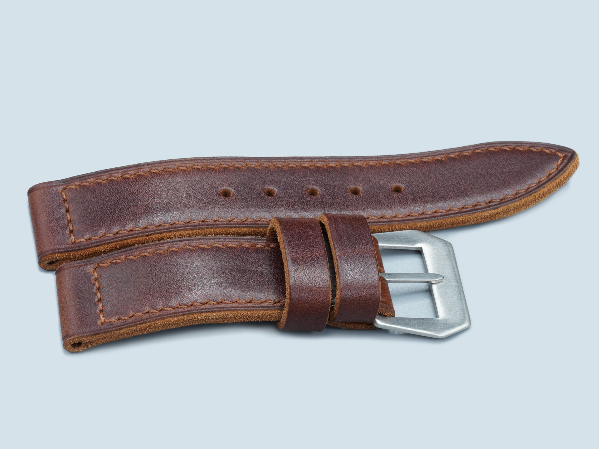 Vintage style watch strap with flat brushed steel buckle.