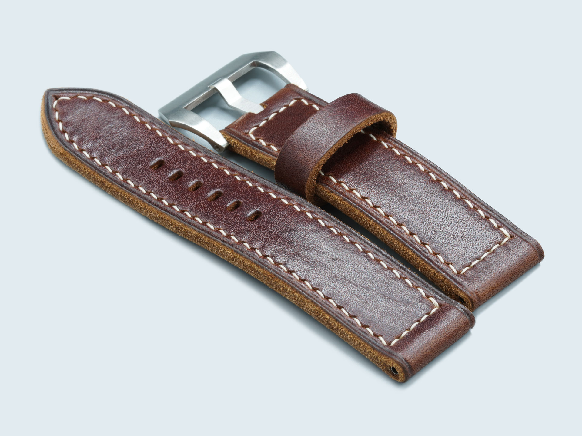Close-up grain texture of handcrafted dark walnut Panerai leather strap