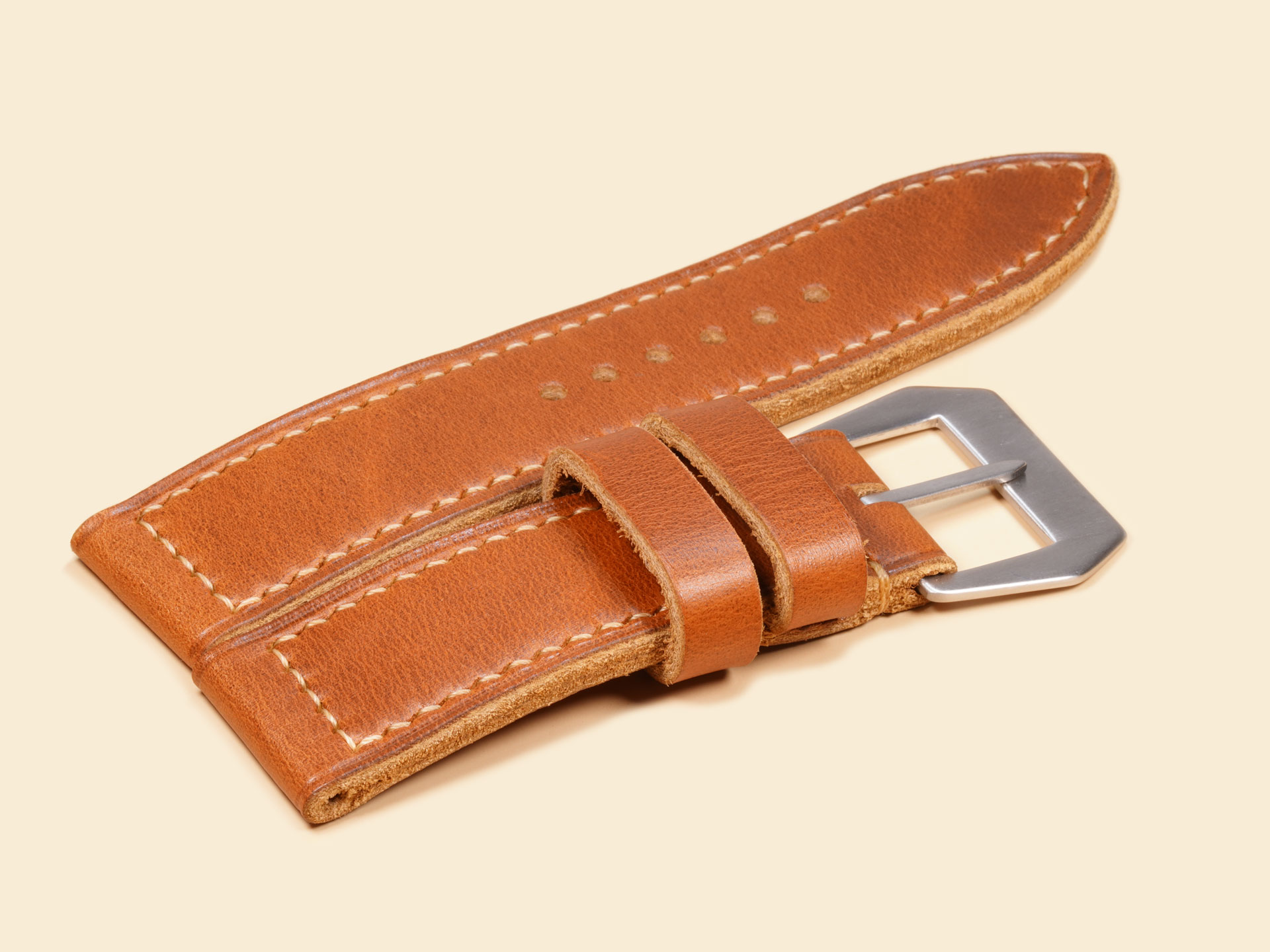 Profile view of a straight 26mm tan leather strap with a classic torpedo tip profile.