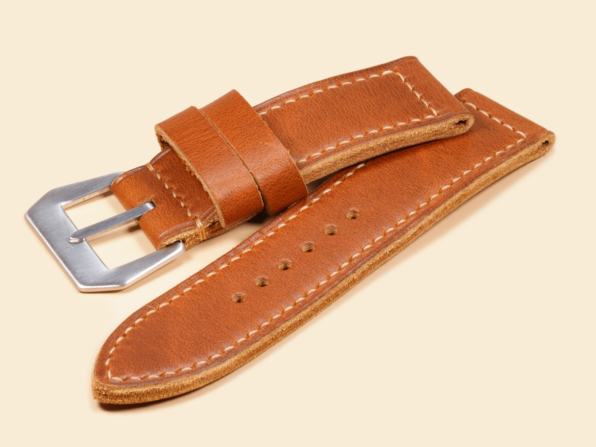 Vintage-style tan leather strap with a reinforced single-fold buckle termination for durability.