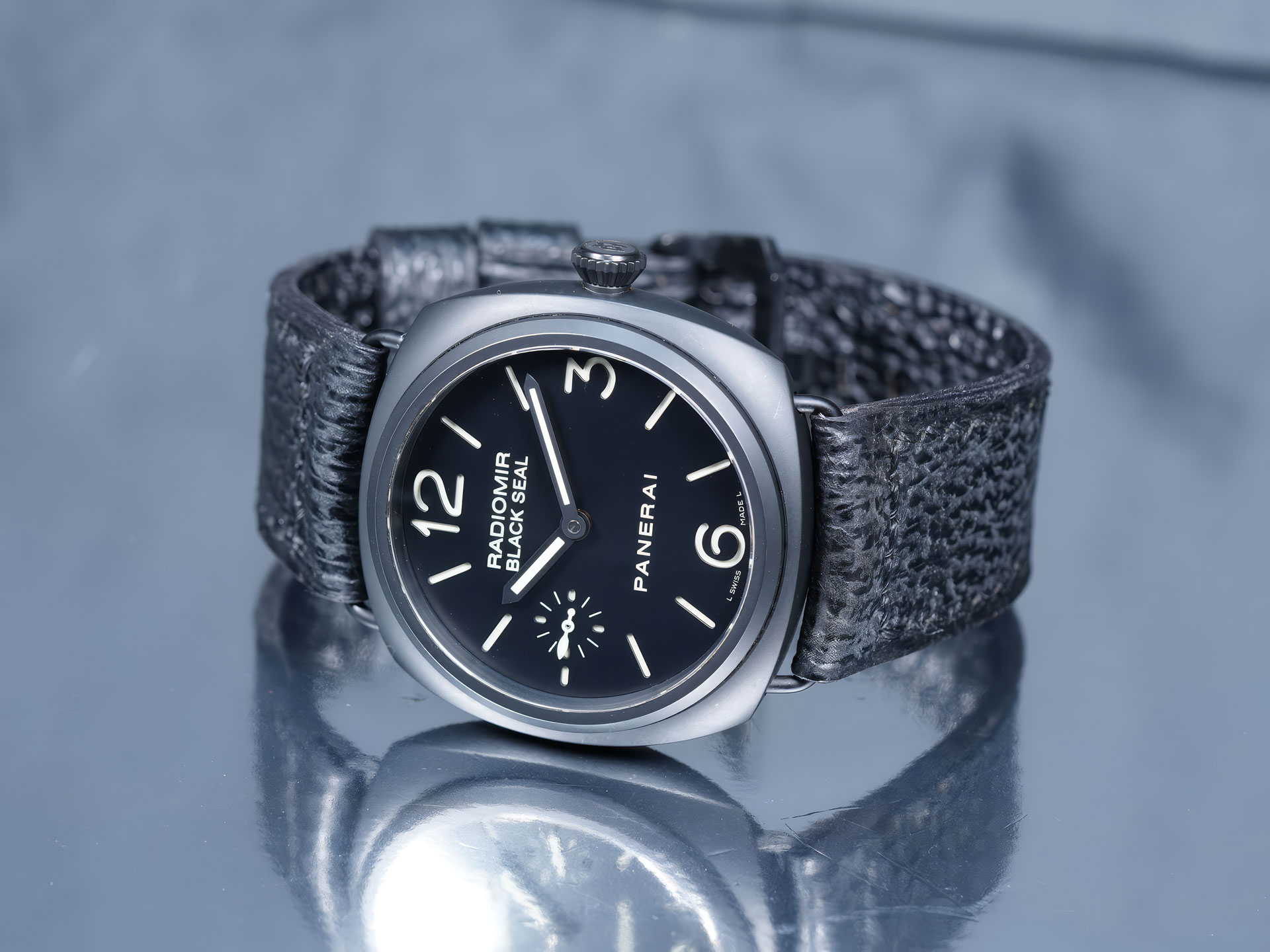 Panerai Radiomir shark strap in Squalo Nero black leather resting on a dark slate background.