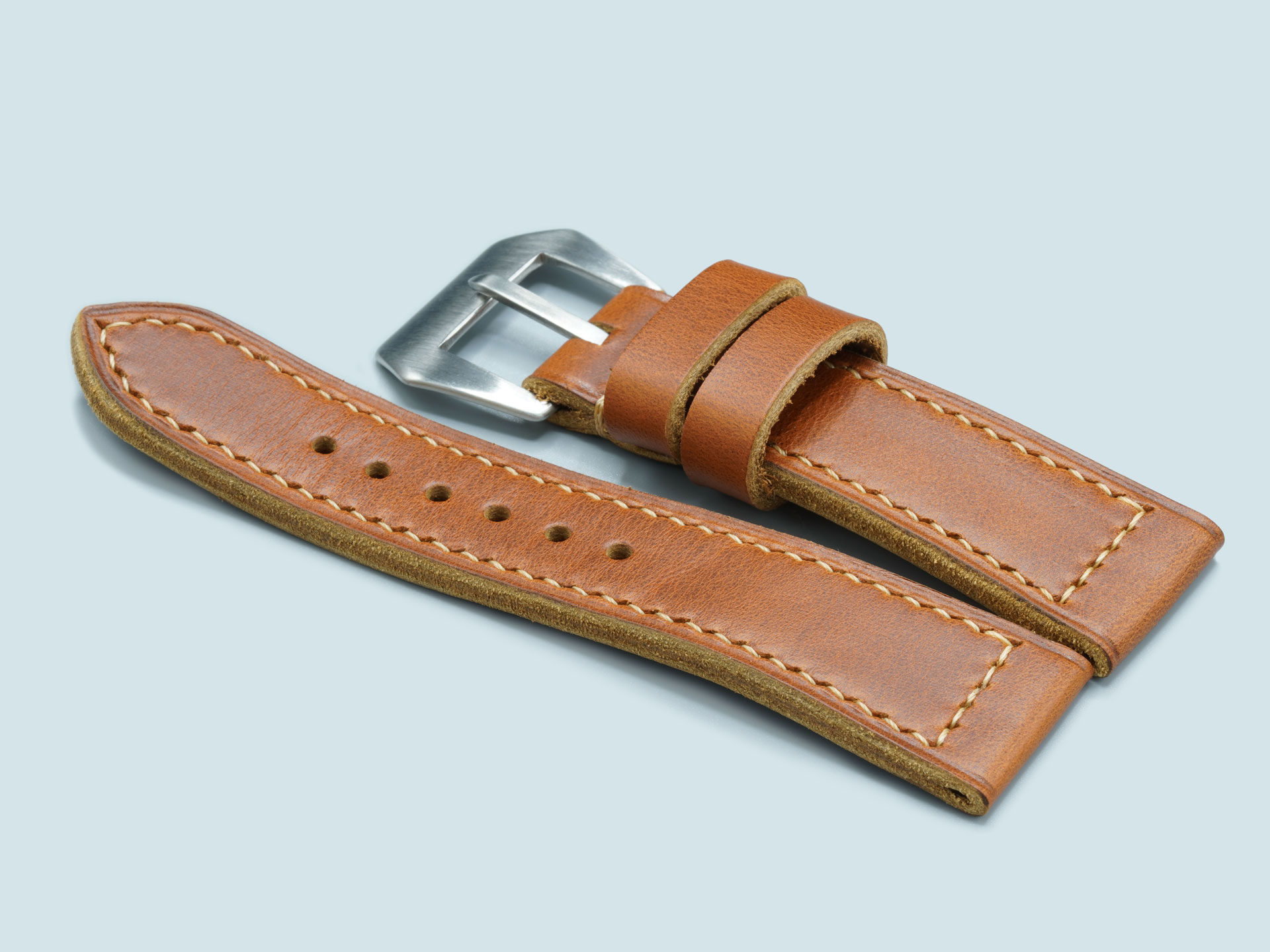 Lug end view of a thick, tan handcrafted Panerai Radiomir strap