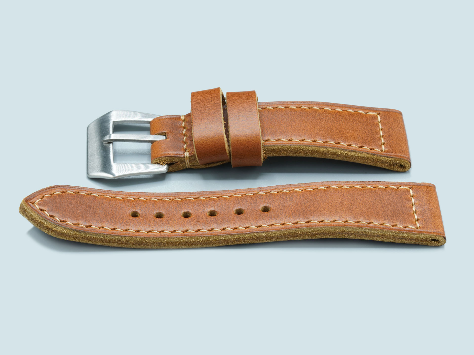 A tan, thick leather Radiomir strap with vintage pin buckle, handcrafted detail