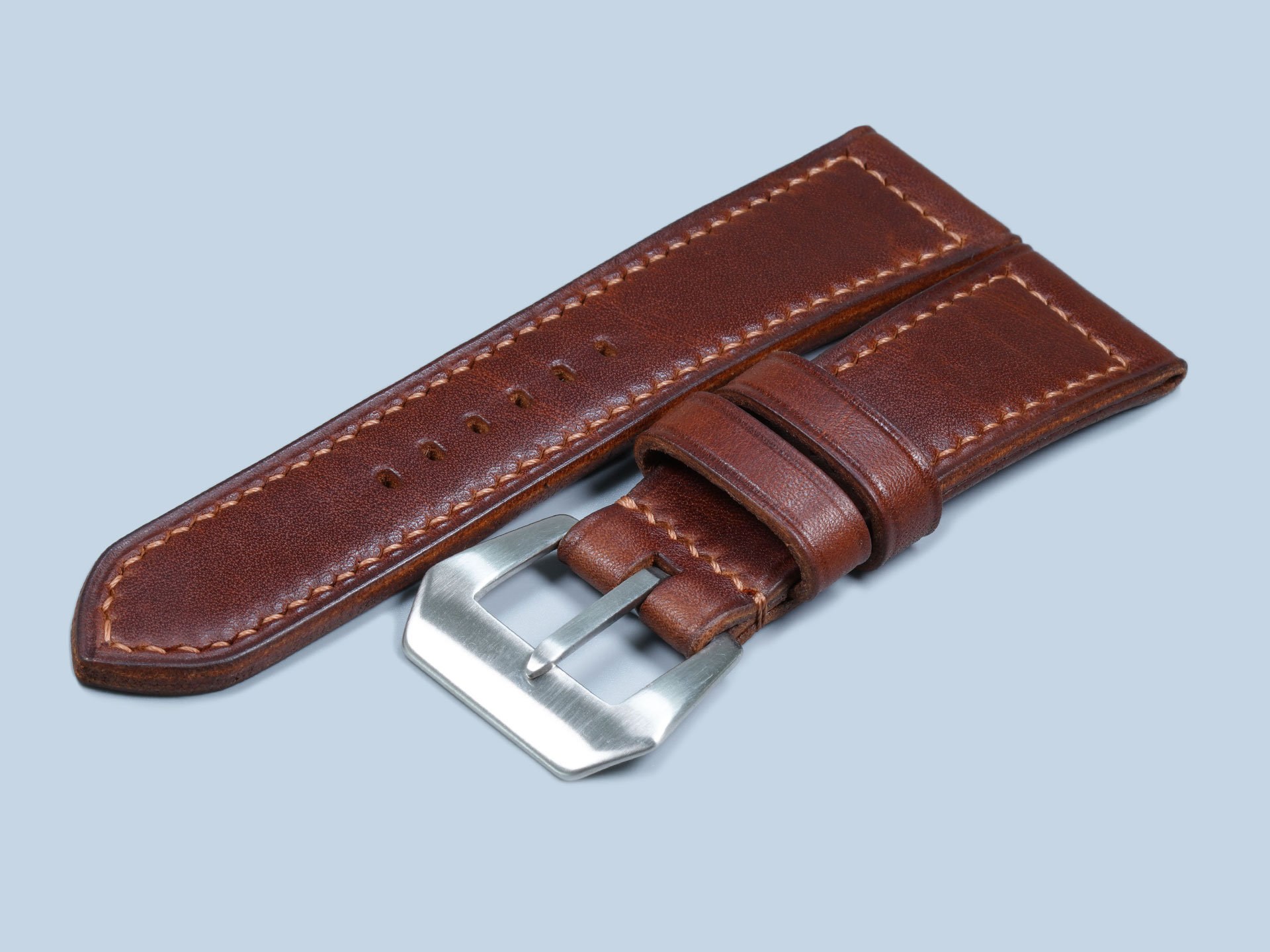 Close-up of dark walnut brown leather watch strap with sewn-in vintage buckle mounted on a Panerai PAM00183 Radiomir.
