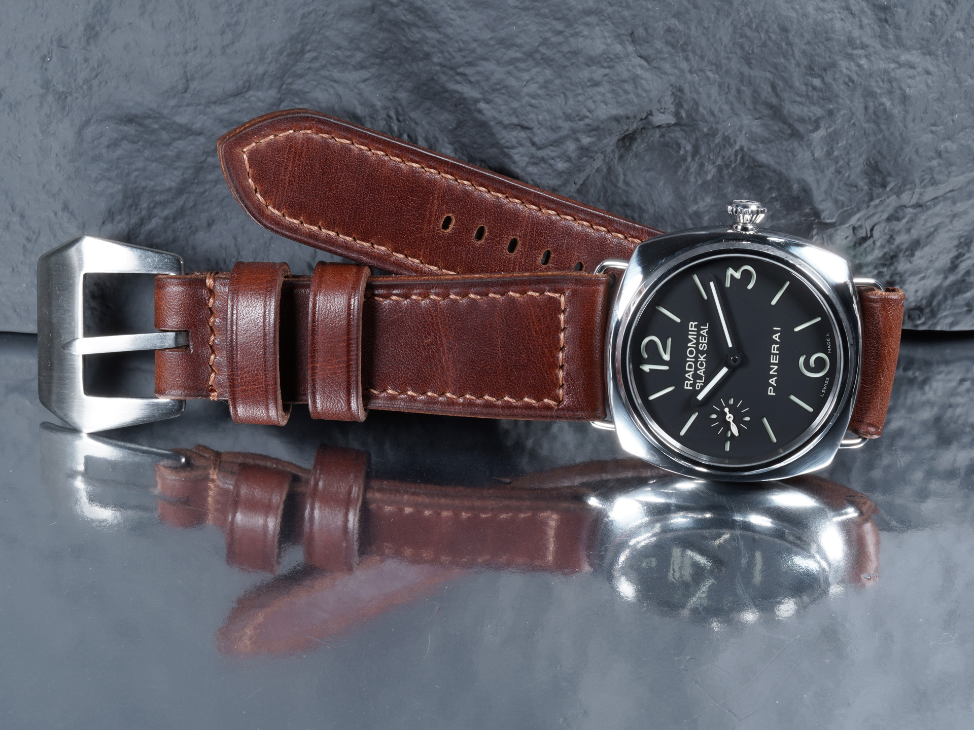 Macro view of dark brown leather texture and contrast stitching on a Panerai Radiomir PAM00183 strap.