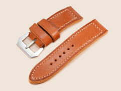 Close-up of 26mm straight-cut lug ends on a tan thick Panerai strap with ivory thread.