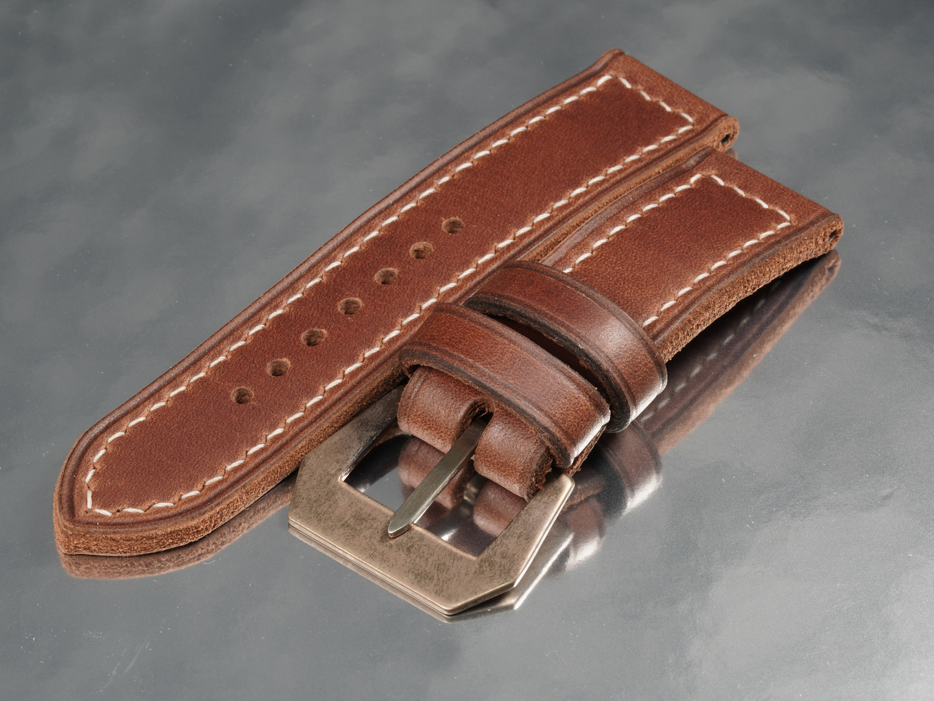Rust brown aged leather strap showing hand-stitched aged pin buckle